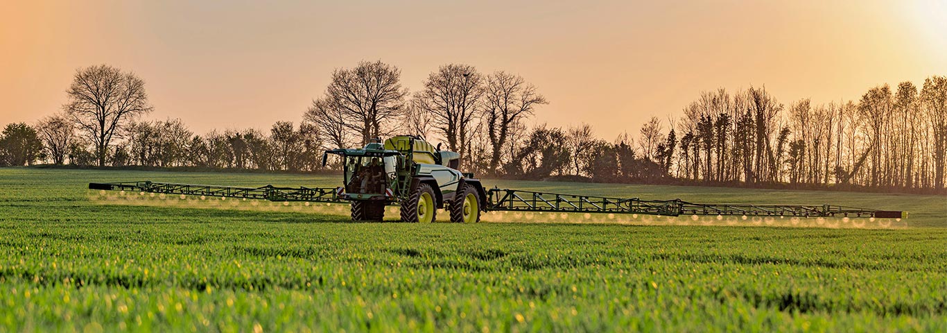 Zemědělsk&yacute; postřikovač John Deere pracuj&iacute;c&iacute; na zelen&eacute;m poli, poskytuj&iacute;c&iacute; přesnou ochranu plodin d&iacute;ky pokročil&eacute; postřikovac&iacute; technologii. Navržen pro přesnost, efektivitu a kvalitn&iacute; pokryt&iacute; plochy.