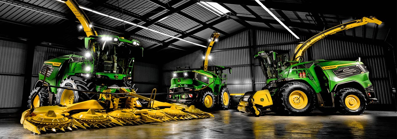 Trinciatrici semoventi John Deere ad alte prestazioni con testate di raccolta premium, esposte al coperto. Scopri la potente tecnologia SPFH progettata per la massima efficienza nella raccolta dei foraggi.