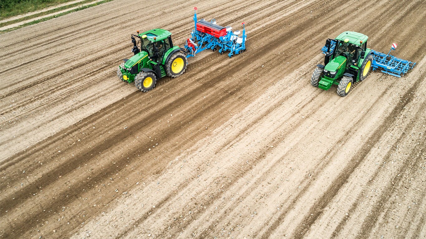 Dva traktory John Deere 6M na&nbsp;zoran&eacute;m poli. Jeden t&aacute;hne sec&iacute; stroj Monsomen. Druh&yacute; t&aacute;hne kultiv&aacute;tor Lemken