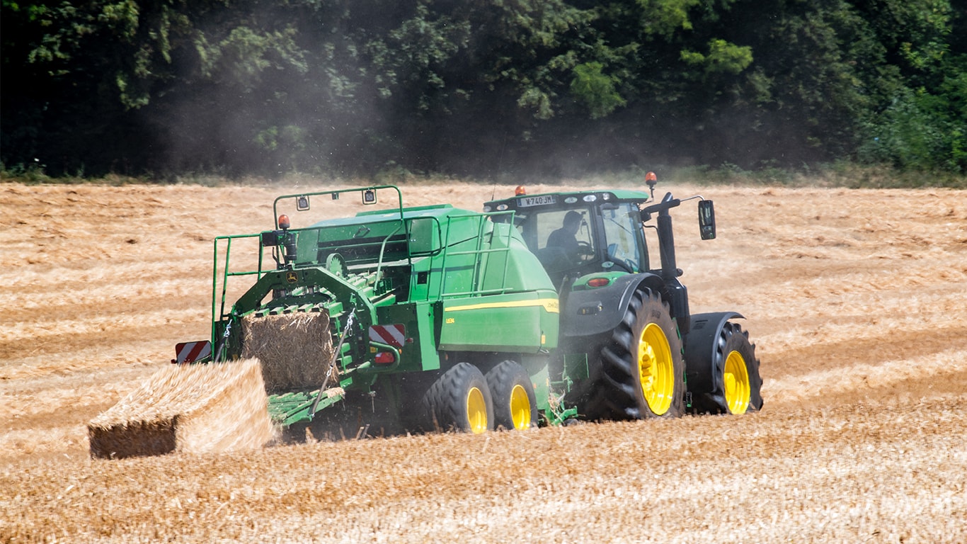 Sběrací lis pro velké hranaté balíky John Deere L634 s traktorem 6R ve slámě