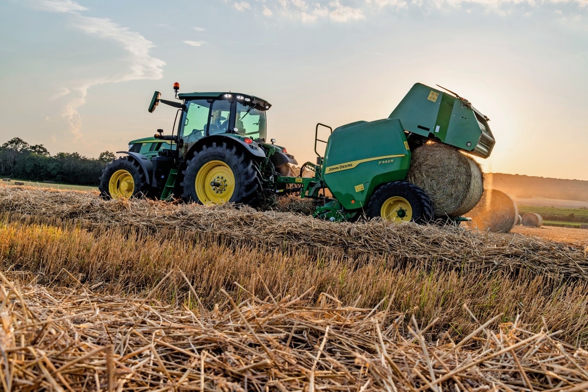 Sběrací lis John Deere F442M tažený traktorem John Deere 6M vyhazující balík slámy