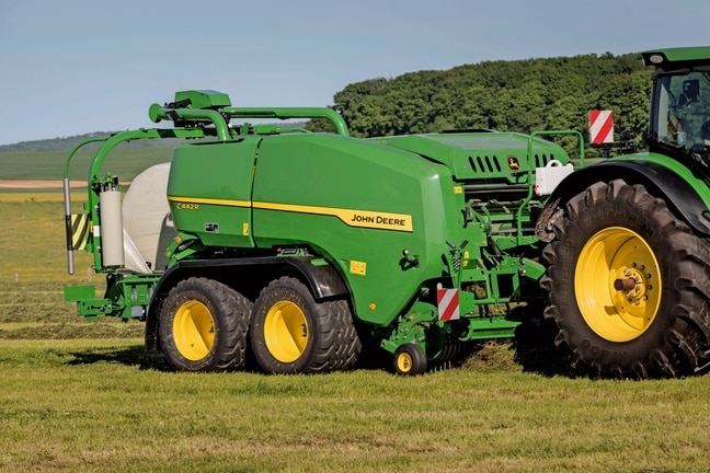 Ovíjecí balíkovač John Deere C442R provádí lisování balíků siláže o vysoké hustotě
